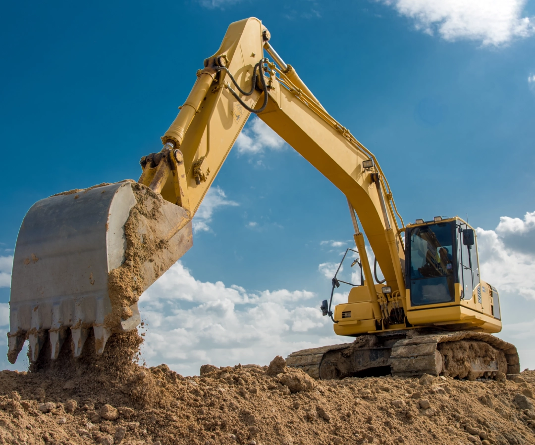 Heavy machinery excavating earth on a sunny day